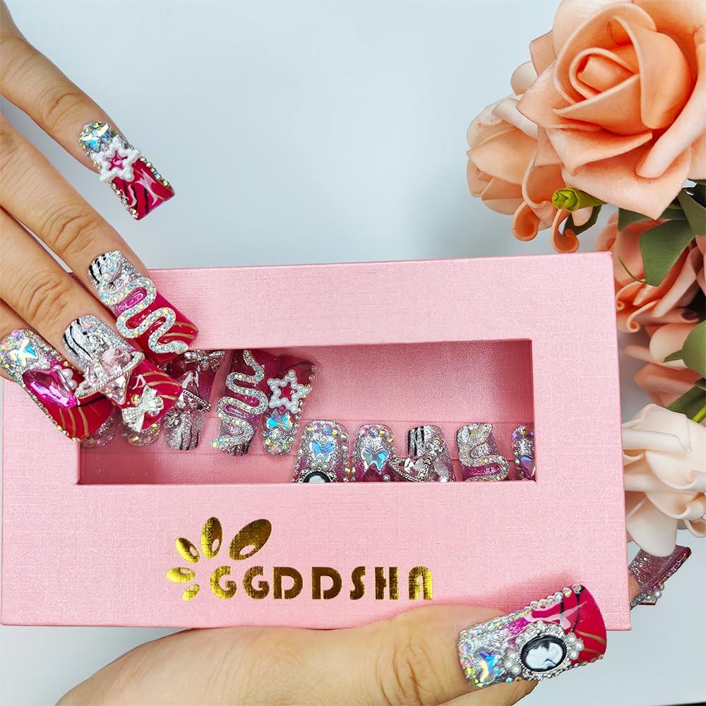 Medium square nails with red and silver glitter, rhinestone stars and ornate swirl details