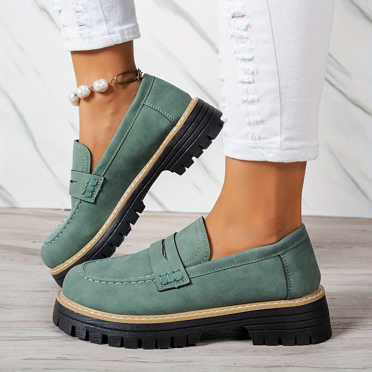 Green round-toe flat loafers with buckle strap and black lug sole