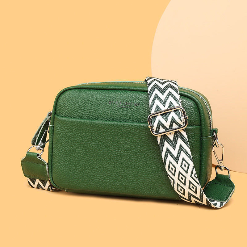 Genuine leather crossbody bag with green body and patterned wide strap with silver buckle