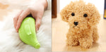 Green pet steam brush held for grooming, shown with a curly-haired dog