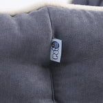 Grey pet bed mattress corner with logo patch and soft beige trim, close-up