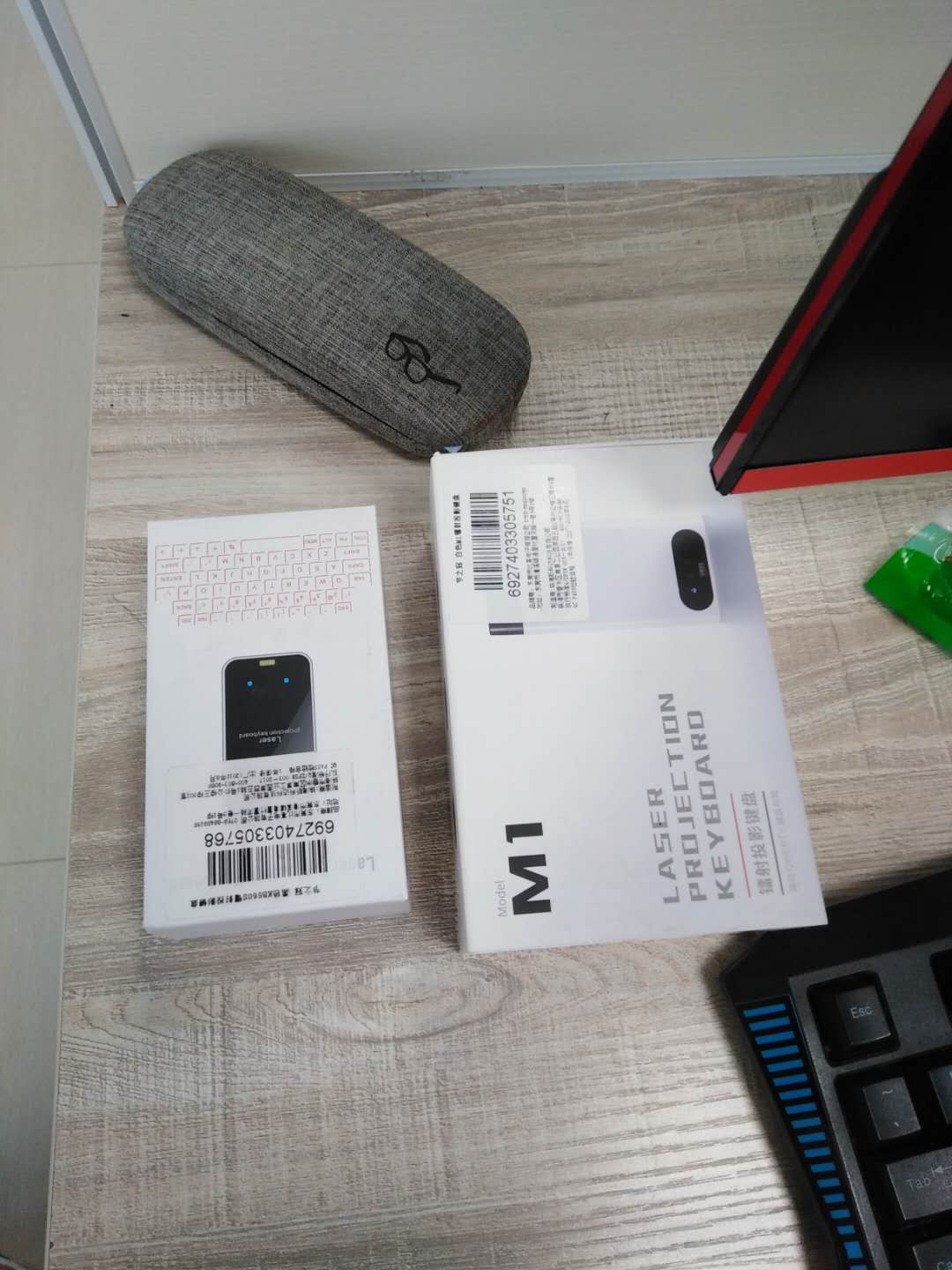 Laser projection keyboard retail boxes and accessories on a desk