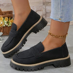 Women’s matte black flat loafer shoes with round toe, buckle strap, and thick tread sole