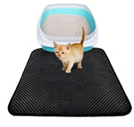 Black cat litter mat with raised rim, holding a cat at litter tray
