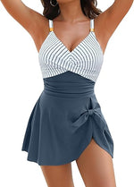 Navy swim dress with thick straps, striped V-neck bodice, and knotted side wrap skirt