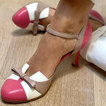 Women’s pointed toe high heel pumps with ankle strap and bow detail, pink, tan, and white.