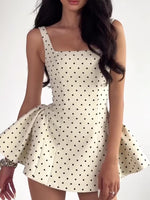 White polka dot sleeveless mini dress with fitted bodice and pleated flare skirt