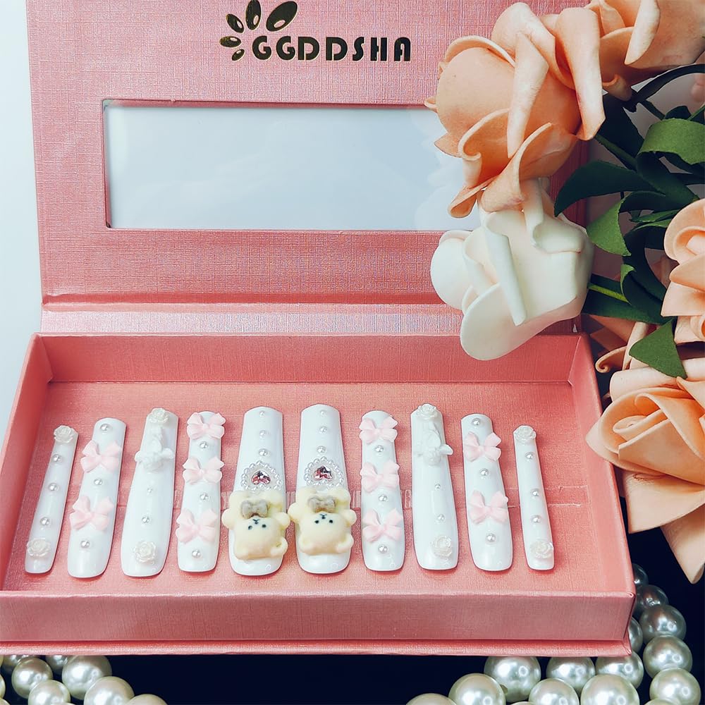 White press-on nails with bear-face centers, bows, and pearl studs in a set