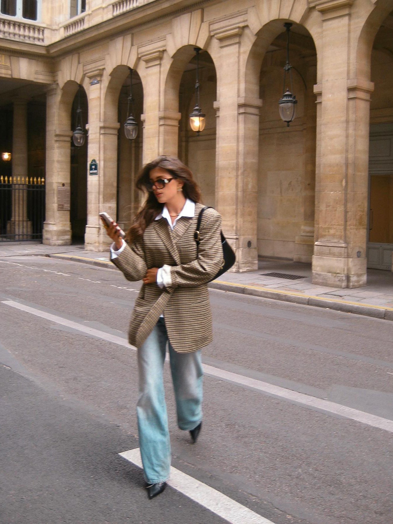 Plaid blazer with notch lapels and long sleeves, worn with light blue jeans and a white shirt