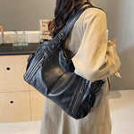 Women’s retro PU handbag with top handles and shoulder strap, black, zip pockets.