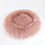 Round shaggy pet sleep bed in pink, with padded rim and inner nest hollow