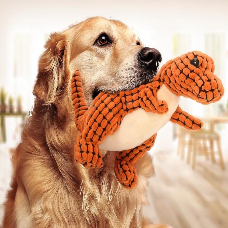Orange plush dinosaur dog toy with black pattern, white belly, and long squeaker body