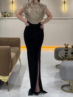 Sleeveless gold sequin high-neck evening dress with black velvet skirt and front slit