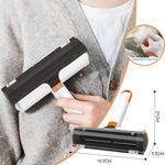 Lint roller with white handle and orange accents, black drum on gray knit fabric