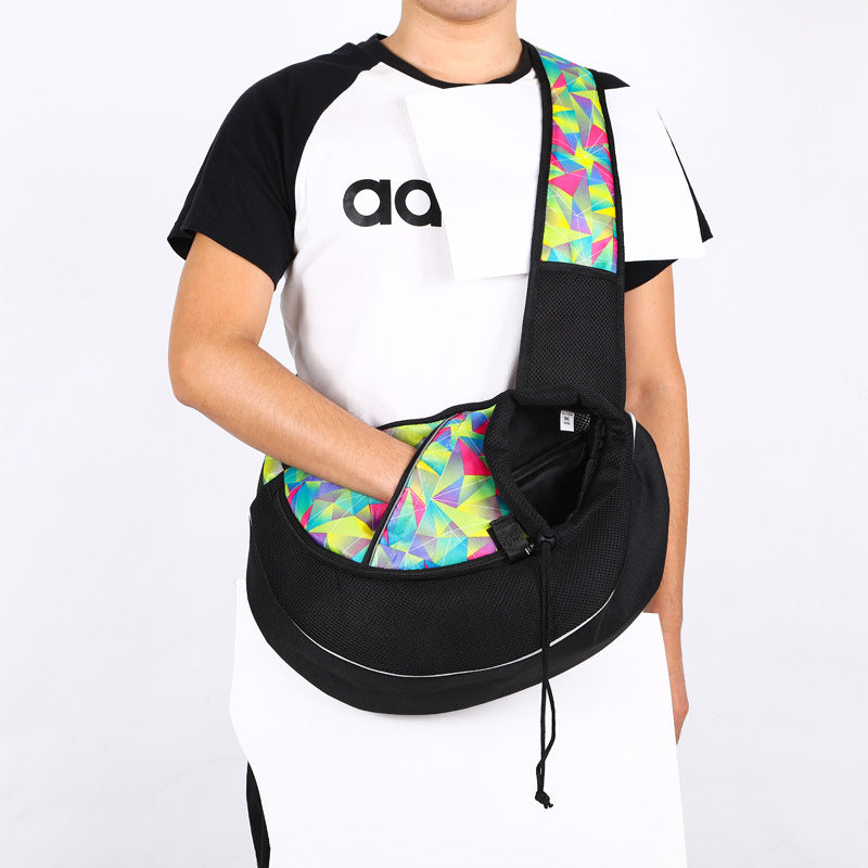 Black pet crossbody bag with multicolor lining and front carrier opening, worn across chest