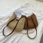 Woven straw shoulder tote with dark brown trim and zipper, with small matching pouch