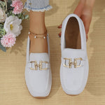 White women’s canvas flat sneakers with gold horsebit-style detail, slip-on design.