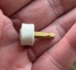 White grinding head on gold shaft held in hand