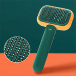 Pet grooming brush with stainless pins, green handle and orange-edged head