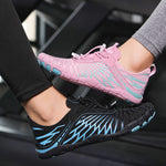 Pink and black water shoes with lace-up design and patterned uppers, worn together.