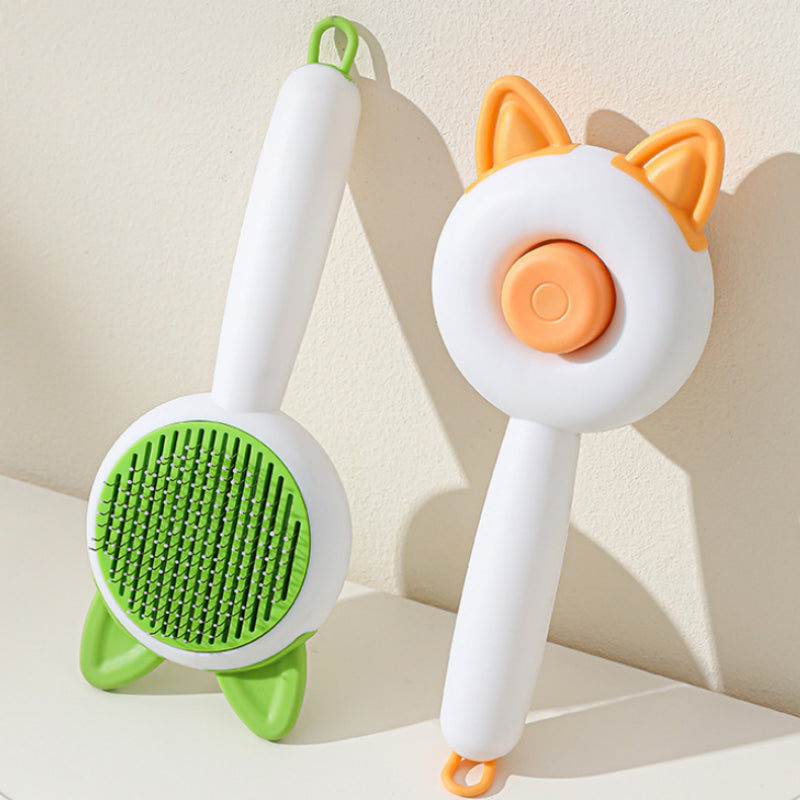 Self-cleaning pet grooming brush with green and orange bristle pads on white handles