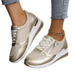 Women's gold lace-up sneakers with side zip, thick white sole and ankle chain detail