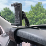 Car dashboard phone holder clip mounted on dash with patterned textured grips, black