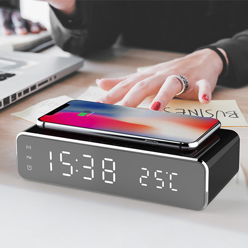 Desktop LED alarm clock with wireless charger, dark gray base, smartphone docked, LED time