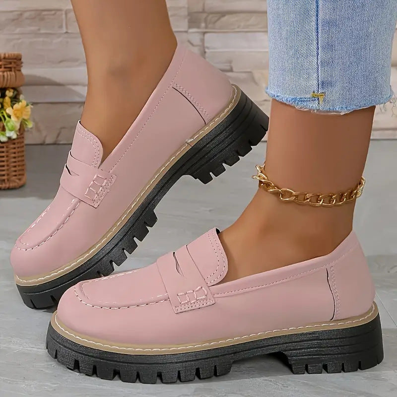 Pink round-toe flat loafers with buckle strap and black lug sole