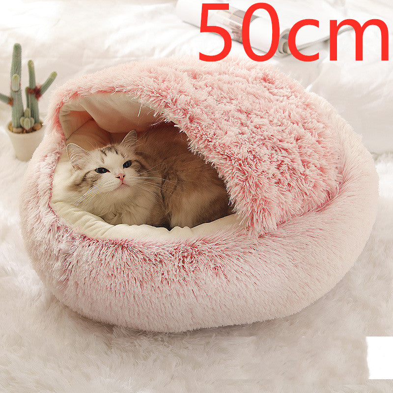 Pink round plush pet bed with raised fuzzy rim, cat resting inside.