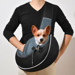 Black pet crossbody bag with blue-gray mesh panel and front carrier opening, holding small dog