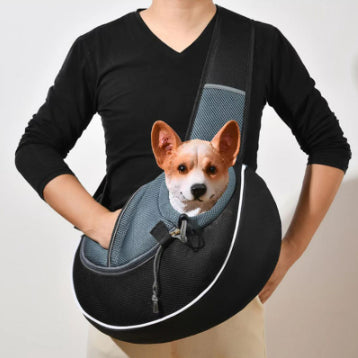 Black pet crossbody bag with blue-gray mesh panel and front carrier opening, holding small dog
