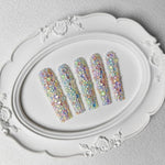 Pastel galaxy long press-on nails on a white tray, covered with multicolor crystal rhinestones