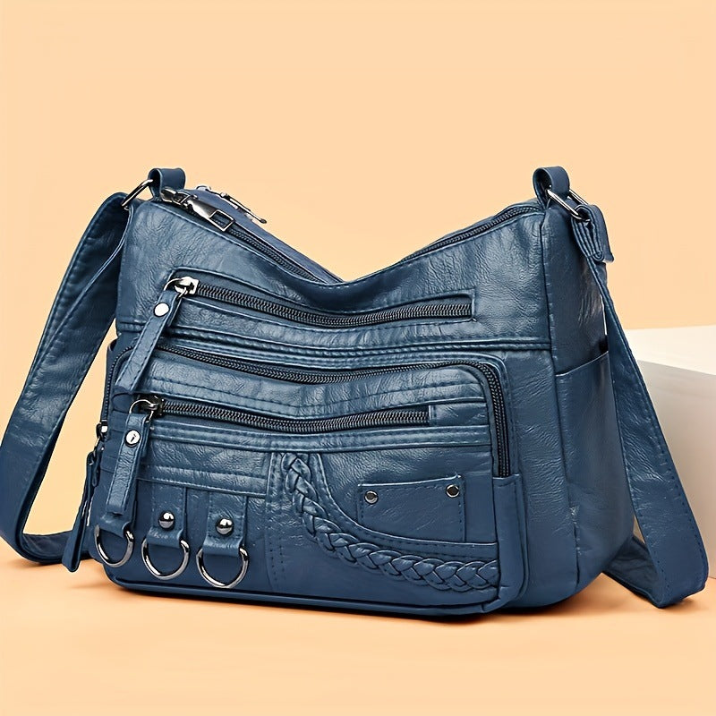 Blue PU leather crossbody bag with multiple zippered sections and braided front pocket