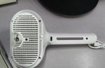 Close-up of white self-cleaning pet comb brush head with bristle teeth and slot openings