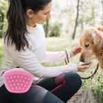Pink silicone dog treat waist pack held while training a dog