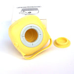 Yellow silicone bath massage brush head with open center cup and snap-on lid