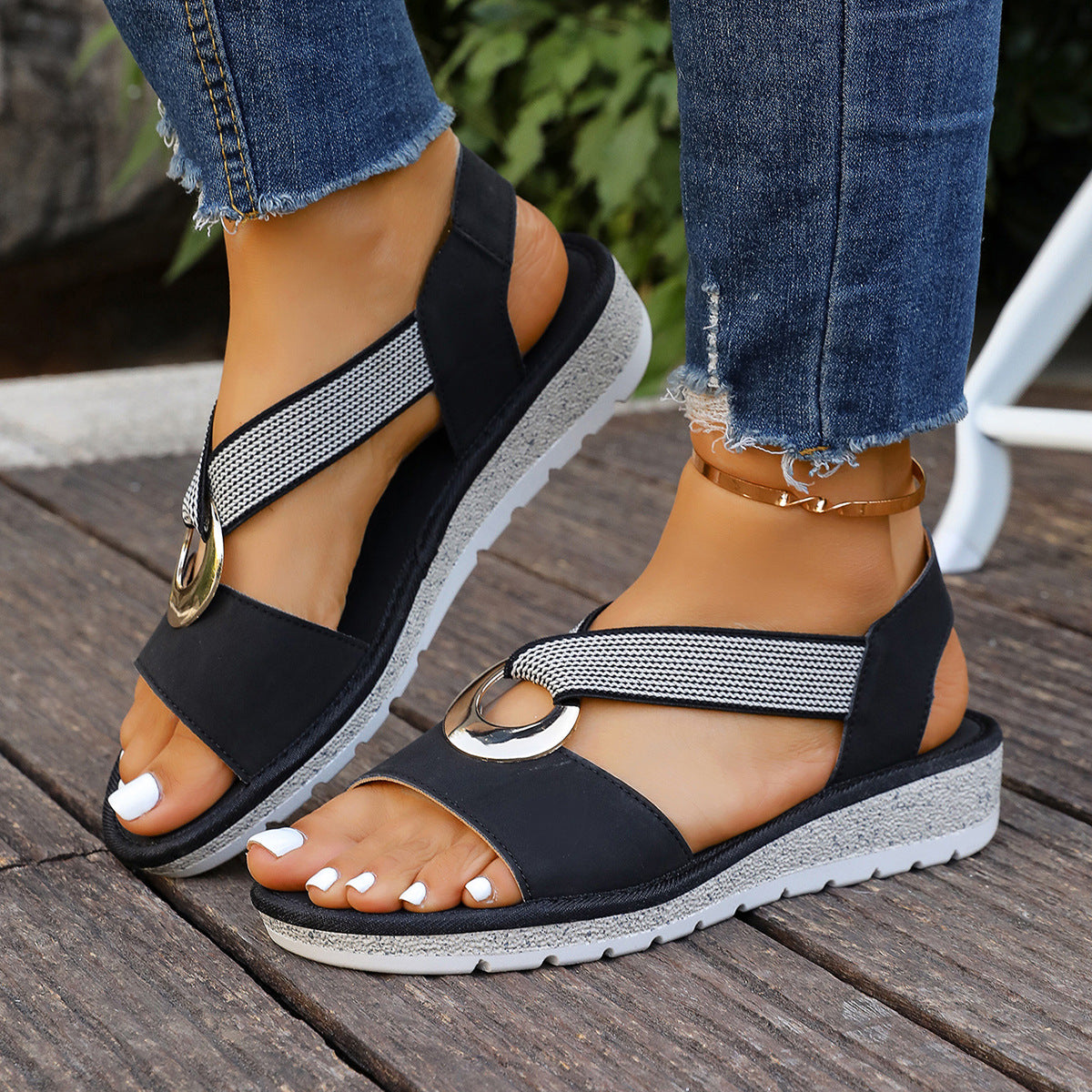Black woven-strap sandals with round gold metal buckles, open toe, cushioned sole