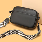 Genuine leather crossbody bag with black textured finish and patterned wide strap