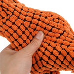 Orange plush dinosaur toy fabric close-up with raised black-and-orange textured pattern