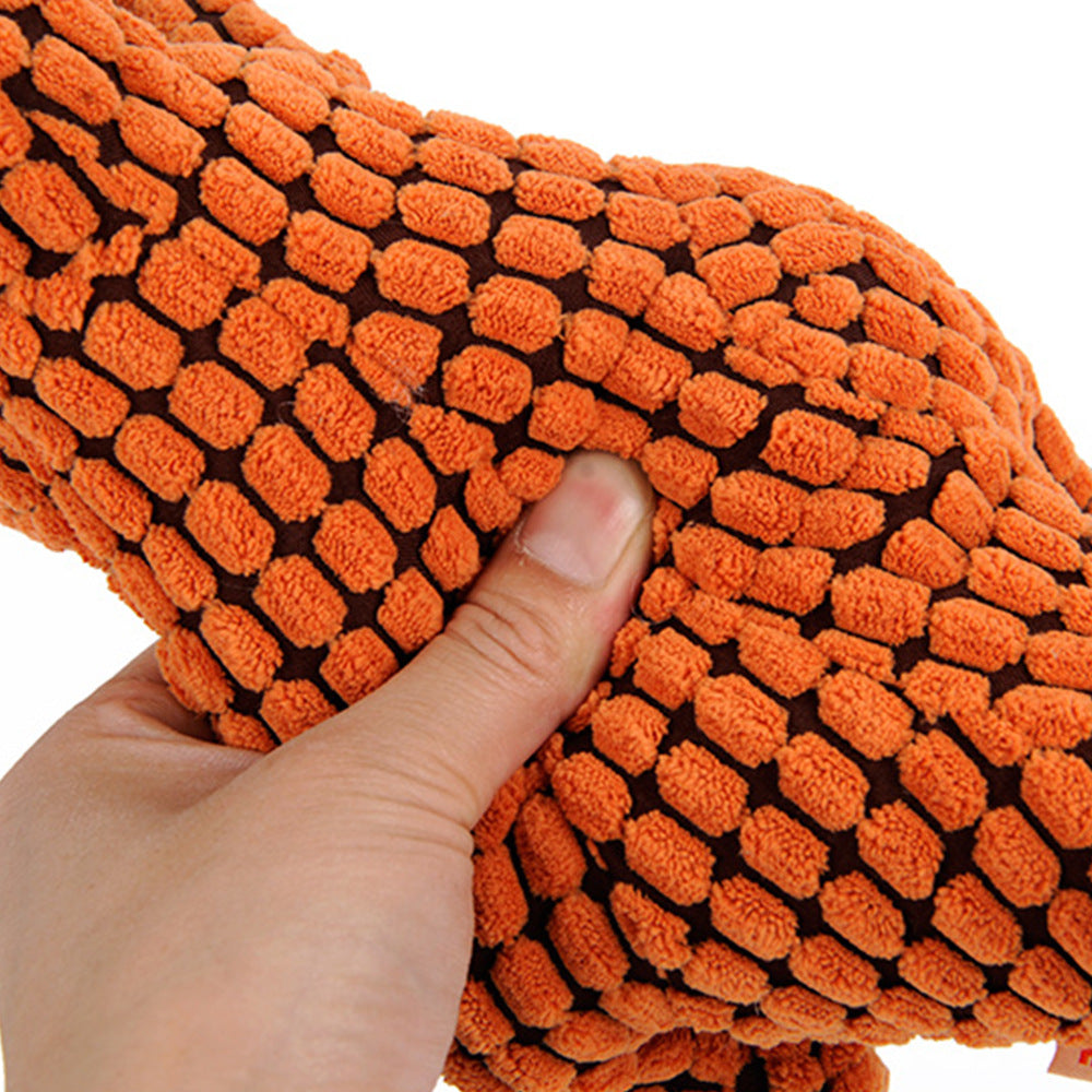 Orange plush dinosaur toy fabric close-up with raised black-and-orange textured pattern