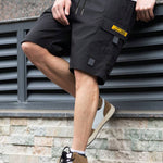 Men's black utility shorts with drawstring, high waist, and flap cargo pockets