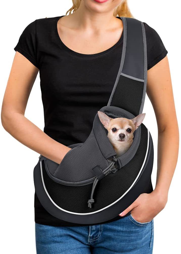 Black pet crossbody bag with cushioned carrier opening and adjustable shoulder strap, on person