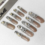 Blush short press-on nails with silver rhinestone trims and oval gems, flat lay