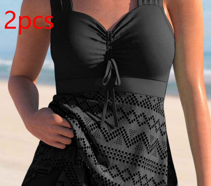 Black lace one-piece swimsuit with padded cups, tie-front neckline, and patterned lace skirt panel