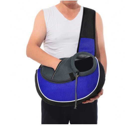 Blue pet crossbody bag with black trim, mesh carrier opening, and adjustable shoulder strap