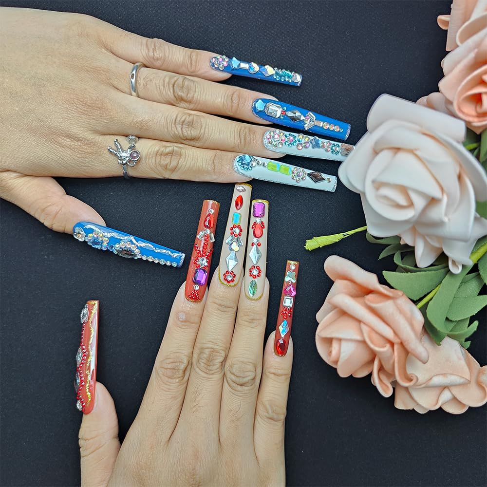 Long press-on nails featuring blue rhinestone details, with red and green accent designs