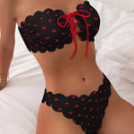 Black printed tube-top bikini with red hearts and tie-front drawstring, scalloped high-waist briefs