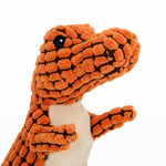 Orange plush dinosaur dog toy with black pattern, white belly panel, and stuffed texture