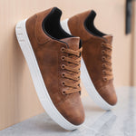 Brown lace-up flat casual shoes with round toe, black collar, and white outsole